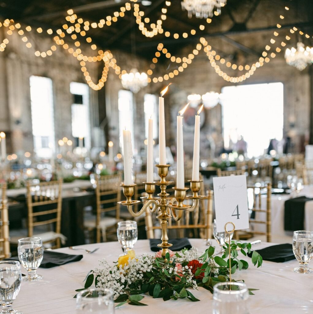 Candelabra centrepiece on a gala table under string lights
