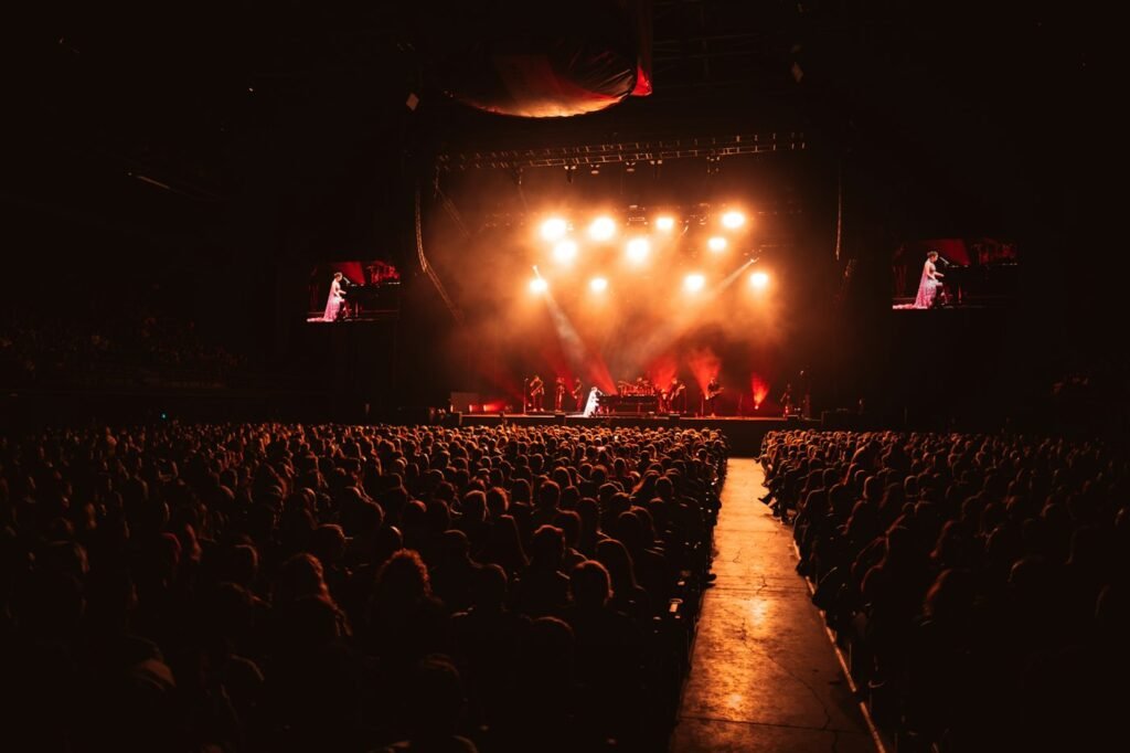 Audience facing a warmly lit concert stage