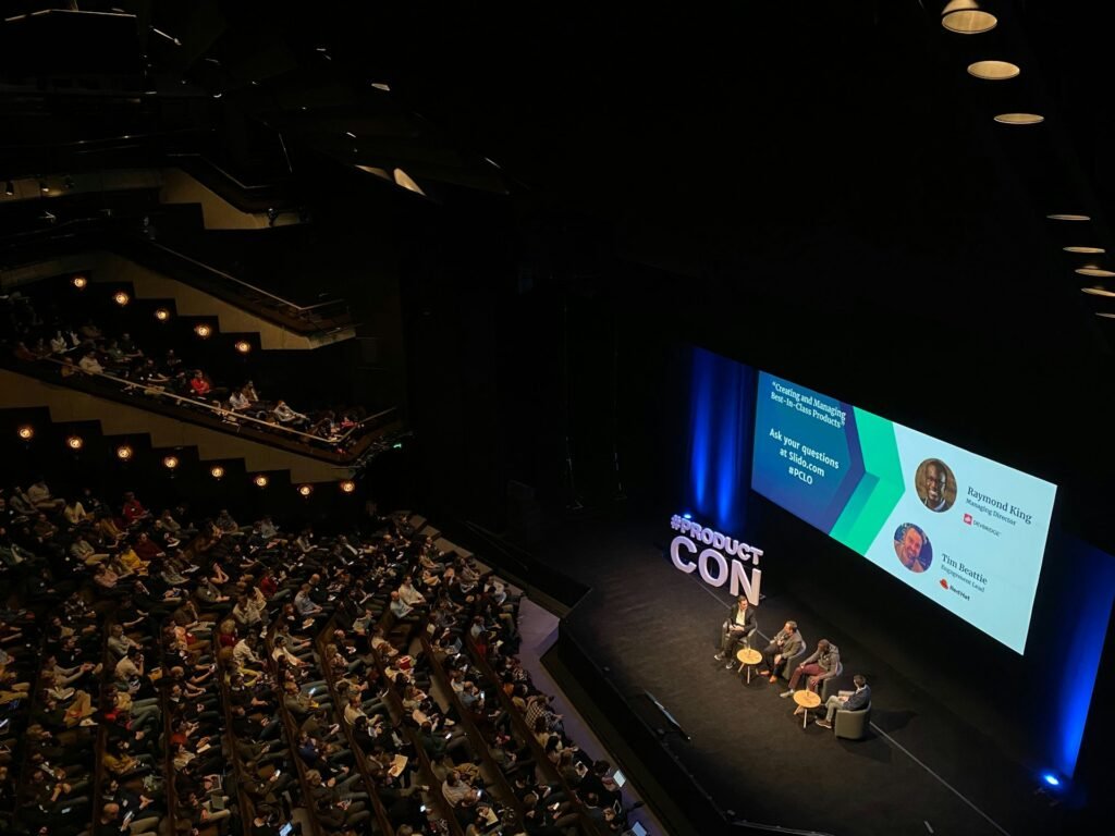 Panel discussion on a conference stage before a full auditorium