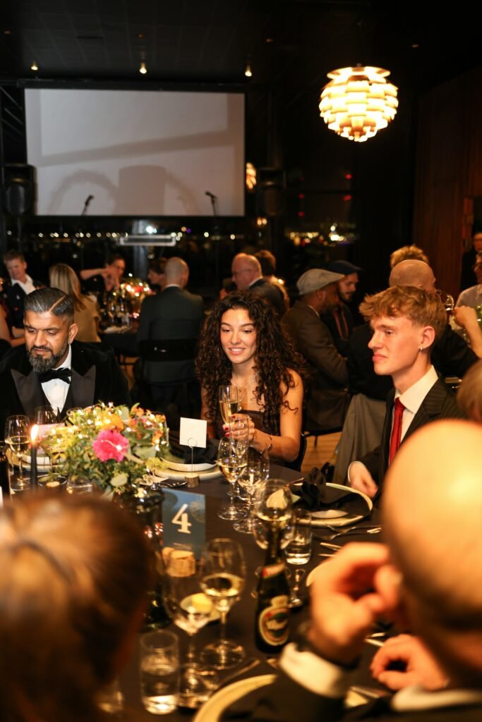 Guests in evening wear at a gala dinner table
