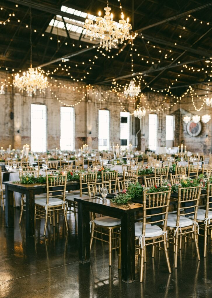 Banquet tables with gold chairs, greenery and candles