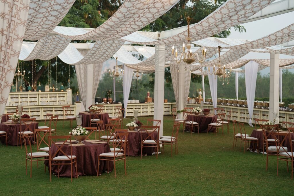 Outdoor reception under draped canopies and chandeliers