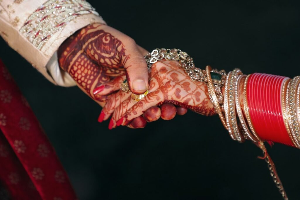 Bride's hennaed hand resting in the groom's